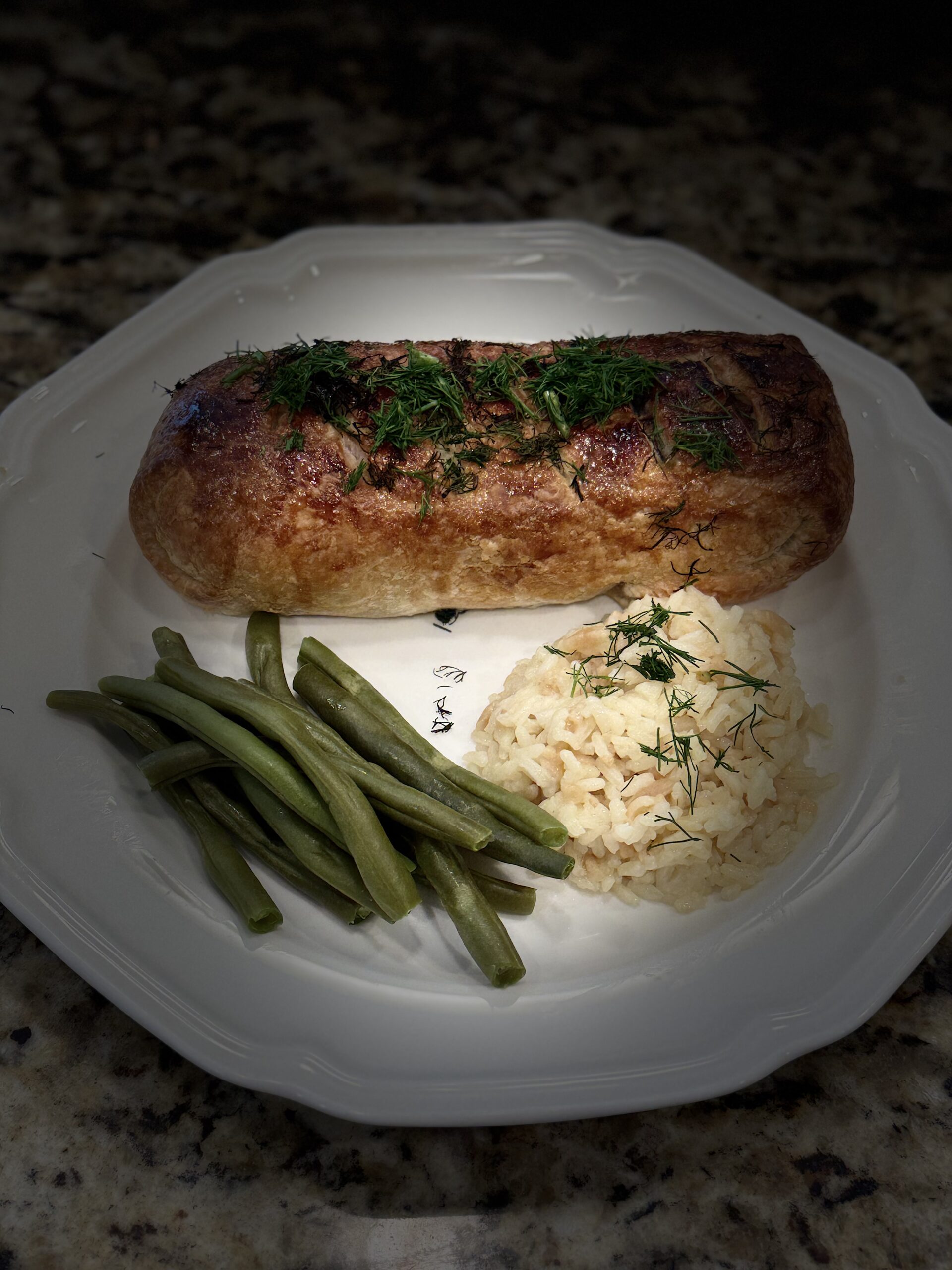 Salmon Wellington, golden puff pastry sliced to reveal salmon and duxelles filling